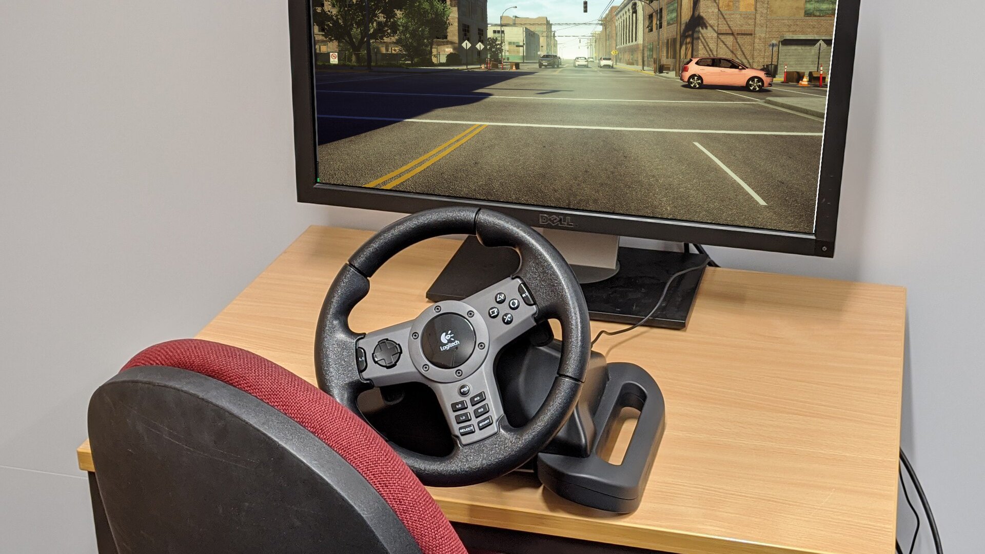 A sim racing rig with a racing seat, wheel and wide screen showing the track